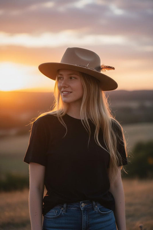 Spirit Warrior Provisions beige wool felt Western hat worn by a woman at sunset in a field