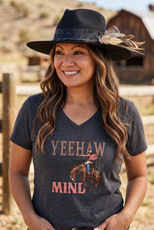 Spirit Warrior Provisions Luna Negra black felt hat with feather detail worn by a smiling woman in a rustic setting
