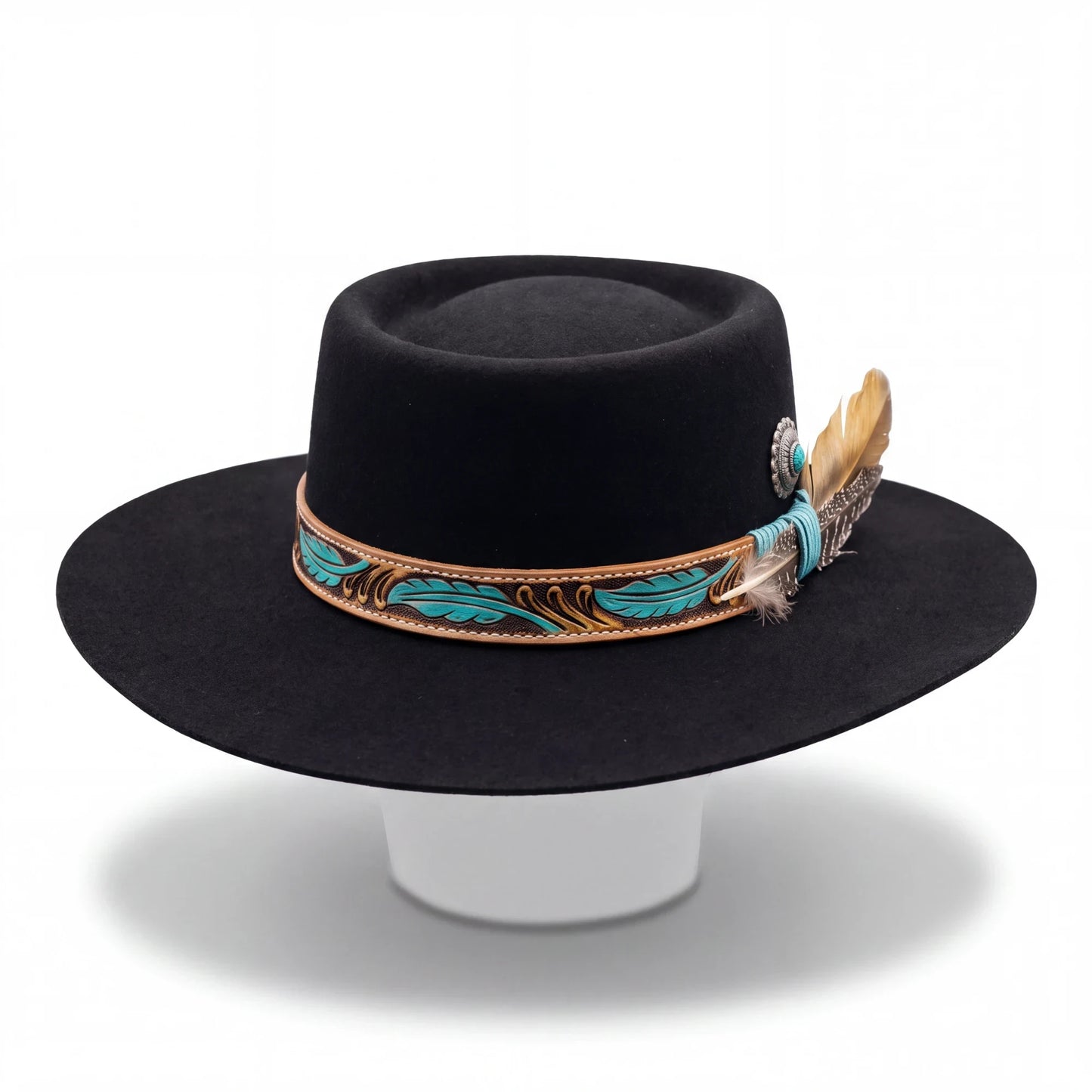 Spirit Warrior Provisions black gambler felt hat with a tooled leather hatband, turquoise feathers, and silver concho.