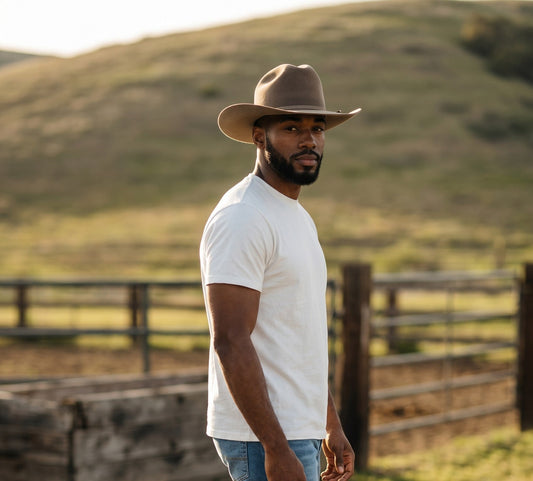 Spirit Warrior Provisions fine felt cattleman cowboy hat in fawn worn by a man in a white t-shirt outdoors.