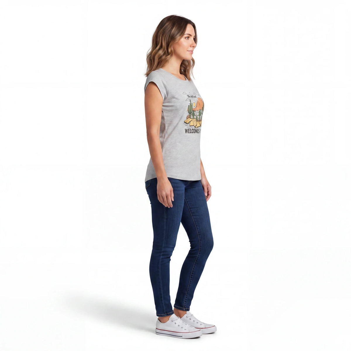 Spirit Warrior Provisions grey cotton graphic tee featuring a desert rodeo design, worn by a woman with blue jeans.