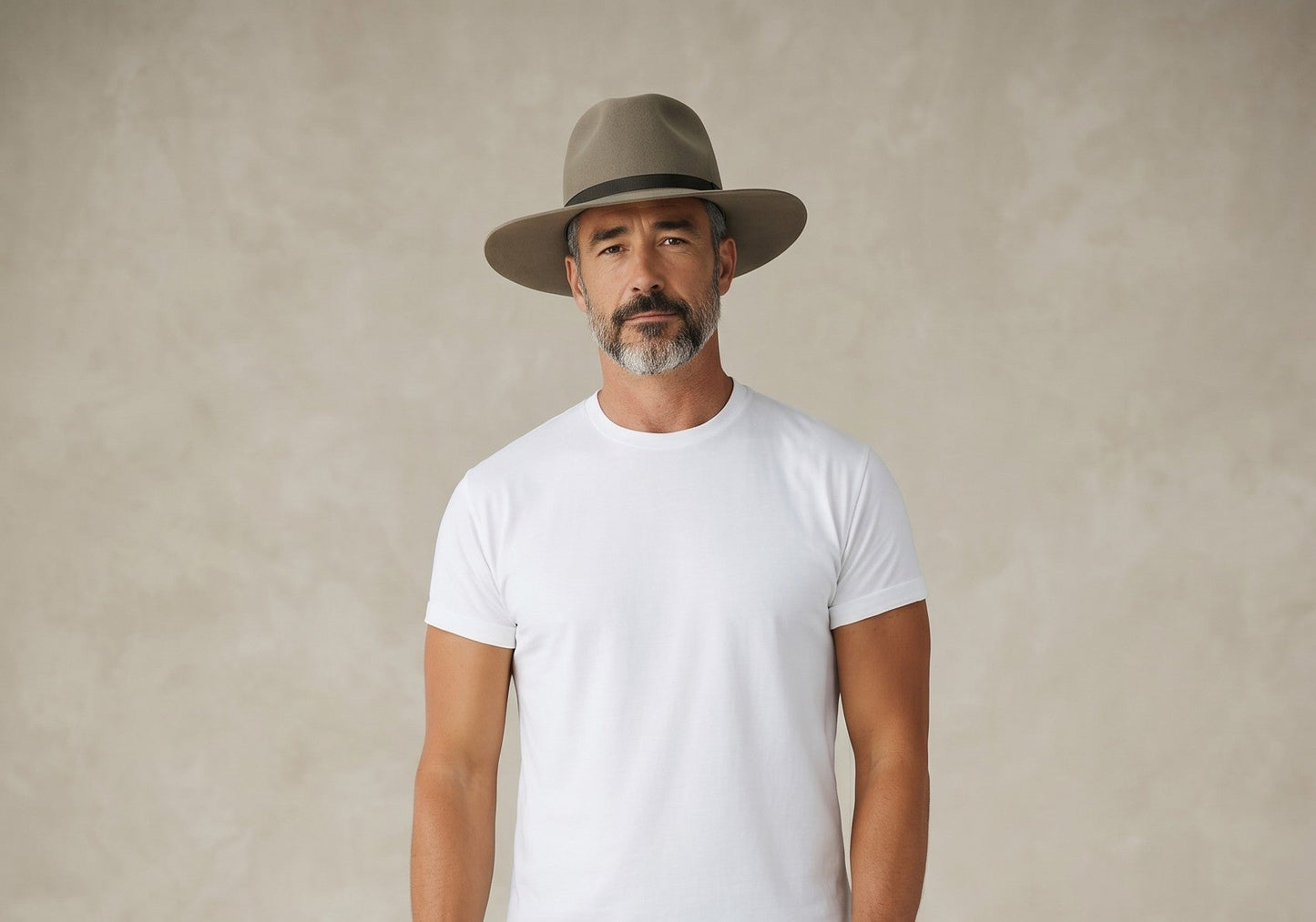 Spirit Warrior Provisions sand felt pinch front cowboy hat with a brown ribbon band worn by a man in a white t-shirt.