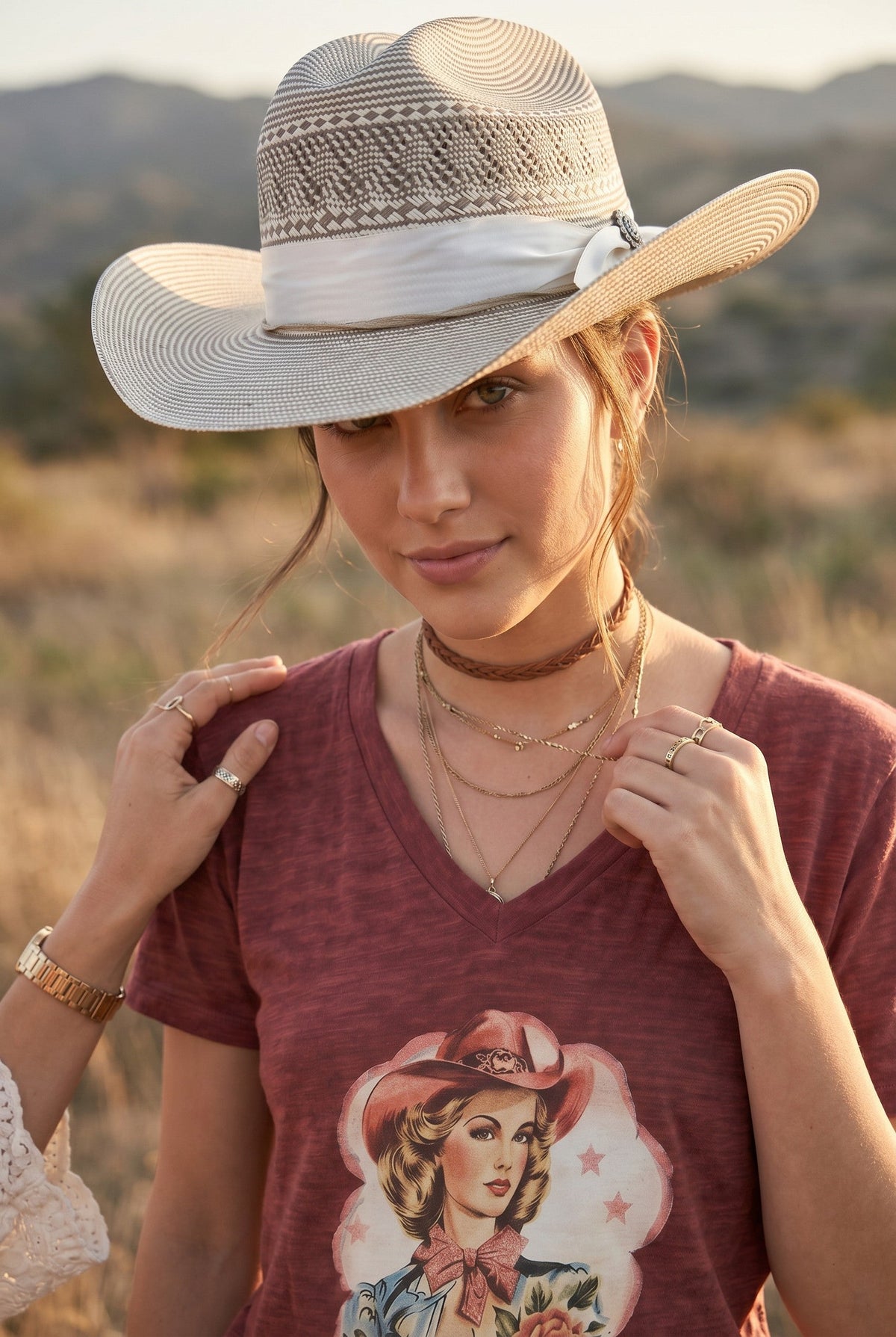 Spirit Warrior Provisions silver Shantung straw cowboy hat with sunflower concho and white ribbon on a woman outdoors
