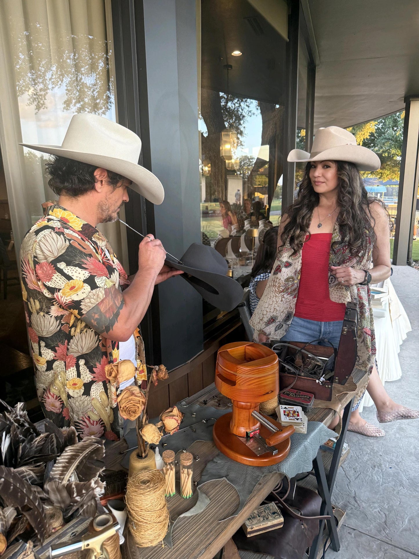 Spirit Warrior Provisions 6X wool felt Western hats in sand and fawn worn by a man and woman at a market stall